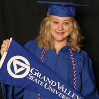 student holding gvsu flag at photo booth
